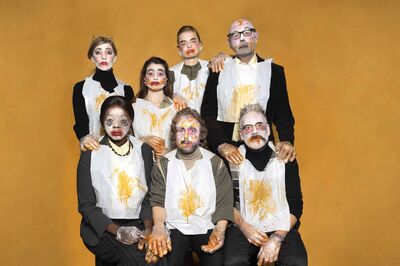 Zeven performers zitten en staan gegroepeerd tegen een okergele achtergrond. Ze dragen witte slabbetjes, doorzichtige plastic handschoenen en hebben expressieve, rommelig aangebrachte grime in felle kleuren op hun gezicht. Hun handen en slabbetjes zijn besmeurd met oranje substantie, wat een absurdistische en ongemakkelijke sfeer oproept. Het is een campagnebeeld voor de voorstelling Byzantium van Het Zuidelijk Toneel.