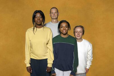 Campagnebeeld voor de voorstelling Holly Goosebumps met vier acteurs die in casual kleding voor een okergele achtergrond staan.