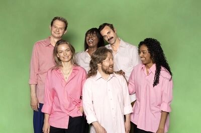 Groepsfoto ensembleleden Het Zuidelijk Toneel, die poseren tegen een groene achtergrond.