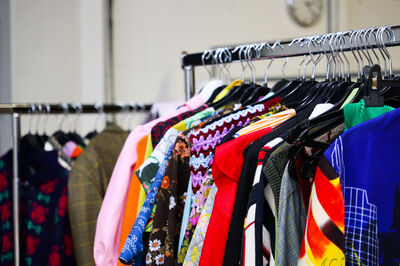 Kledingrek met diverse kleurrijke outfits en accessoires in het kostuumverhuur van Het Zuidelijk Toneel.