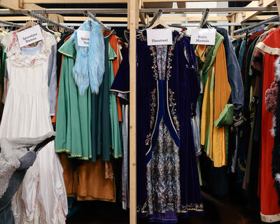 Afbeeldingen van de kostuumverhuur van Het Zuidelijk Toneel, met rekken vol kleding, accessoires en theaterkostuums in een kleurrijke en geordende opslagruimte.