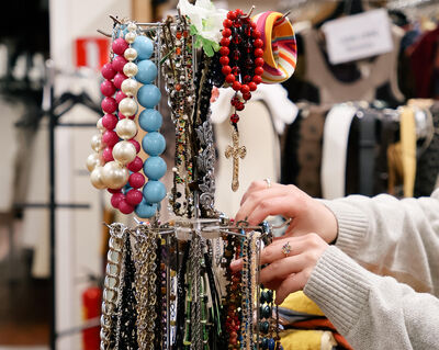 Afbeeldingen van de kostuumverhuur van Het Zuidelijk Toneel, met rekken vol kleding, accessoires en theaterkostuums in een kleurrijke en geordende opslagruimte.