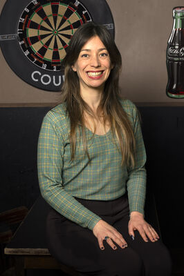 Regisseur Jessie L'Herminez poseert in bruin café