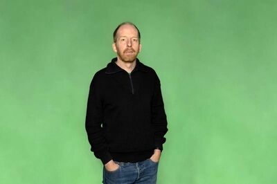 Portretfoto maker Jetse Batelaan van Het Zuidelijk Toneel, poserend tegen een groene achtergrond.