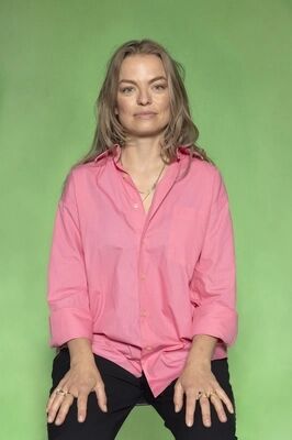 Portretfoto ensemblelid Keja Klaasje Kwestro van Het Zuidelijk Toneel, die poseert tegen een groene achtergrond.