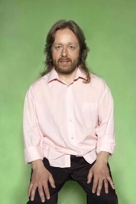 Portretfoto ensemblelid Louis van der Waall van Het Zuidelijk Toneel, die poseert tegen een groene achtergrond.
