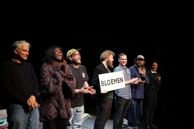 Acteurs houden op het podium een bordje omhoog met daarom 'Bloemen' in plaats van fysieke bloemen te krijgen.